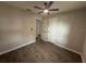 Bedroom featuring neutral paint, wood-look tile floors, multiple doors and a ceiling fan at 212 Dorothy St, Auburndale, FL 33823