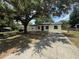 Inviting home with a spacious driveway, lush yard, and mature trees, offering curb appeal and outdoor space at 212 Dorothy St, Auburndale, FL 33823