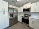 Well-equipped kitchen with modern stainless steel appliances, white cabinets, and ample countertop space at 212 Dorothy St, Auburndale, FL 33823
