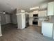 Modern kitchen featuring stainless steel appliances, white cabinets, stone countertops, and stylish lighting at 212 Dorothy St, Auburndale, FL 33823