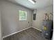 Utility room with grey water heater, wood-look tile floors and a bright window at 212 Dorothy St, Auburndale, FL 33823