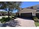 Attractive townhouse featuring a paved driveway and mature tree in the front yard at 2183 Leather Fern Dr, Ocoee, FL 34761