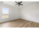 Bright, minimalist bedroom with a ceiling fan and large window offering scenic views at 22212 Sw 210Th Ave, Dunnellon, FL 34431