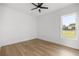 Bedroom with wood floors, ceiling fan, window and white walls at 22212 Sw 210Th Ave, Dunnellon, FL 34431