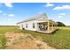 Exterior view of a white farmhouse with a metal roof and wrap-around porch at 22212 Sw 210Th Ave, Dunnellon, FL 34431