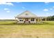 Charming farmhouse with a large front porch, pink doors, and a beautifully maintained lawn at 22212 Sw 210Th Ave, Dunnellon, FL 34431
