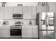 Close up of stainless steel appliances and gray cabinets with tile backsplash in a bright kitchen at 22212 Sw 210Th Ave, Dunnellon, FL 34431