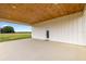 Covered patio featuring a stained wood ceiling and a door to the backyard at 22212 Sw 210Th Ave, Dunnellon, FL 34431