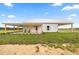 Rear exterior view of a white farmhouse with a metal roof and covered parking at 22212 Sw 210Th Ave, Dunnellon, FL 34431