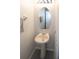 Well-lit powder room features pedestal sink, large oval mirror, and painted gray wood-look flooring at 2241 Retreat View Cir, Sanford, FL 32771