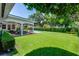 Lush backyard with a covered patio, dining area, swimming pool, and manicured landscaping at 2527 Shrewsbury Rd, Orlando, FL 32803