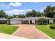 Charming single-story home with a brick driveway, a two-car garage, and a well-manicured lawn at 2527 Shrewsbury Rd, Orlando, FL 32803