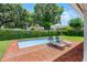 Backyard pool featuring a brick patio, lounge chairs, striped umbrella, and privacy landscaping at 2527 Shrewsbury Rd, Orlando, FL 32803