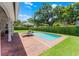 Beautiful backyard swimming pool with brick patio, lounge chairs, striped umbrella, and well-manicured landscaping at 2527 Shrewsbury Rd, Orlando, FL 32803