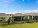 A home featuring a screened lanai and backyard with a black metal fence and grass at 2759 Purple Meadow Ct, Minneola, FL 34715