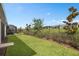 Backyard features lush green grass, defined landscaping, and a sleek fence for privacy at 2759 Purple Meadow Ct, Minneola, FL 34715