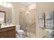 Well-lit bathroom with a glass-enclosed shower, vanity with countertop, and towel racks at 2759 Purple Meadow Ct, Minneola, FL 34715