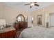 Bedroom featuring a decorative mirror, neutral walls, wood floors, and doorway to bathroom and hallway at 2759 Purple Meadow Ct, Minneola, FL 34715