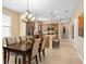 Open-concept dining area leading to the kitchen features a modern chandelier and tile flooring at 2759 Purple Meadow Ct, Minneola, FL 34715