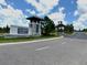 Entrance to Del Webb Minneola, featuring a stone sign, landscaping, and a paved entrance at 2759 Purple Meadow Ct, Minneola, FL 34715