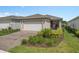 Charming single-story home featuring a well-manicured front yard, brick driveway, and a two-car garage at 2759 Purple Meadow Ct, Minneola, FL 34715