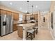 Well-lit kitchen boasts stainless steel appliances, granite countertops, and a cozy island with seating at 2759 Purple Meadow Ct, Minneola, FL 34715