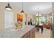 Kitchen island boasts granite countertops with views of the dining and living spaces at 2759 Purple Meadow Ct, Minneola, FL 34715