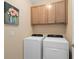 Functional laundry room with cabinets above the washer and dryer units at 2759 Purple Meadow Ct, Minneola, FL 34715