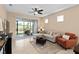 Cozy living room features tile flooring, comfortable seating, and a sliding glass door to the patio at 2759 Purple Meadow Ct, Minneola, FL 34715