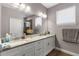 Bathroom features double sinks, granite countertops, white cabinets, a large mirror, and a shower with glass door at 308 Clearwater Ln, Poinciana, FL 34759