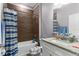 Bathroom featuring a tub and shower, granite counters, wood-look tile, and matching accessories at 308 Clearwater Ln, Poinciana, FL 34759