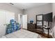 Bright bedroom with a plush bed, contemporary dresser, and a mounted television for relaxation at 308 Clearwater Ln, Poinciana, FL 34759