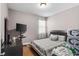 Comfortable bedroom featuring a cozy bed, sleek black dresser, and mounted television for relaxation at 308 Clearwater Ln, Poinciana, FL 34759