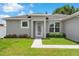 Close-up of a home's entrance, highlighting the pristine walkway and decorative garden at 308 Clearwater Ln, Poinciana, FL 34759