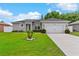 Charming single-story home featuring a well-manicured lawn and an attached two-car garage at 308 Clearwater Ln, Poinciana, FL 34759