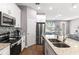 Bright kitchen with stainless appliances, granite counters, an island with a sink and an open view into dining area at 308 Clearwater Ln, Poinciana, FL 34759