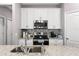 Modern kitchen features white cabinetry, stainless steel appliances, granite countertops, and stylish backsplash at 308 Clearwater Ln, Poinciana, FL 34759
