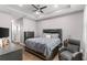 A main bedroom with a tray ceiling, fan, dresser, nightstands, and an upholstered headboard on a bed at 308 Clearwater Ln, Poinciana, FL 34759