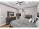 A main bedroom with a tray ceiling, fan, dresser, nightstands, TV, and an upholstered headboard on a bed at 308 Clearwater Ln, Poinciana, FL 34759