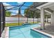 Stunning pool with a cascading water feature, surrounded by a screened enclosure for privacy at 308 Clearwater Ln, Poinciana, FL 34759