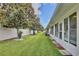 Spacious backyard with lush green grass, mature trees along a fence line and white house at 3415 Celena Cir, St Cloud, FL 34769