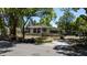 An older home with boarded up windows, a damaged roof, and overgrown front yard is surrounded by trees at 3914 W Robinson St, Orlando, FL 32805