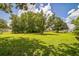 Well-maintained backyard featuring lush lawn and mature trees, perfect for outdoor enjoyment at 426 Illinois Ave, St Cloud, FL 34769