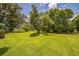 Spacious backyard with lush grass and mature trees providing shade and a serene environment at 426 Illinois Ave, St Cloud, FL 34769