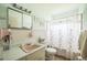Quaint bathroom with pink tile accents and vintage fixtures at 426 Illinois Ave, St Cloud, FL 34769