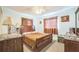 Comfortable bedroom with wooden bed frame, dark curtains, and side tables at 426 Illinois Ave, St Cloud, FL 34769