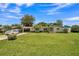 Charming single story home with a manicured lawn, mature trees, and a white car in the driveway at 426 Illinois Ave, St Cloud, FL 34769