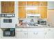 Well-equipped kitchen featuring wood cabinets, white appliances, and functional cooking space at 426 Illinois Ave, St Cloud, FL 34769