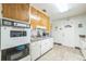 Functional kitchen featuring wood cabinets, white appliances, and easy access to the back door at 426 Illinois Ave, St Cloud, FL 34769