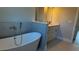 Modern bathroom showcases a sleek soaking tub with stylish fixtures and a gray tiled surround at 4437 Sw 159Th Pl, Ocala, FL 34473